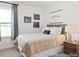 Well-lit bedroom featuring a tan coverlet, a large window, and stylish decor at 157 N District Ave # 291, Clayton, NC 27527