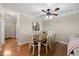 Charming dining area with wood floors, a ceiling fan, and a window offering a peek into the kitchen at 1602 Township Cir, Raleigh, NC 27609