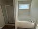 Bathroom showcasing a modern soaking tub and a glass-enclosed shower at 171 Tulipfield Way, Benson, NC 27504