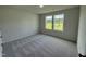 Bedroom with gray carpet and natural light streaming through the double windows at 171 Tulipfield Way, Benson, NC 27504