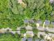 Aerial view of a home surrounded by lush trees and a neighborhood street at 1717 Martin Luther King Jr Blvd, Raleigh, NC 27610