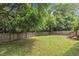 The backyard features green grass, mature trees, a wooden deck and a wood fence at 1717 Martin Luther King Jr Blvd, Raleigh, NC 27610