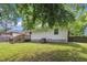 The backyard features green grass, a wooden deck, mature trees, and a white home exterior at 1717 Martin Luther King Jr Blvd, Raleigh, NC 27610