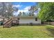 The backyard features green grass, a wooden deck, mature trees, and a white home exterior at 1717 Martin Luther King Jr Blvd, Raleigh, NC 27610