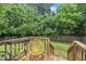 Backyard with a wooden deck, green grass, mature trees, and a wood fence at 1717 Martin Luther King Jr Blvd, Raleigh, NC 27610