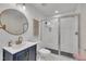 Modern bathroom featuring gold hardware, a glass shower and a round mirror at 1717 Martin Luther King Jr Blvd, Raleigh, NC 27610