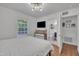 Well-lit bedroom with an ensuite bathroom, a modern dresser, and large window views at 1717 Martin Luther King Jr Blvd, Raleigh, NC 27610
