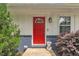 Close-up of a bright red front door with decorative glass, a Ring doorbell, and manicured landscaping at 1717 Martin Luther King Jr Blvd, Raleigh, NC 27610