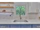 Close-up of a kitchen sink, marble backsplash, designer window and brass faucet at 1717 Martin Luther King Jr Blvd, Raleigh, NC 27610
