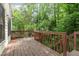 Wooden back deck surrounded by lush greenery, perfect for outdoor relaxation at 1720 Kingston Heath Way, Raleigh, NC 27604