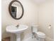 Powder room featuring a pedestal sink, toilet, decorative mirror, and sconce lighting at 1720 Kingston Heath Way, Raleigh, NC 27604