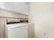 Functional laundry room with a washing machine, dryer, storage cabinets, and shelving at 1720 Kingston Heath Way, Raleigh, NC 27604