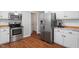 Open kitchen view with stainless steel refrigerator and appliances, white cabinets, and modern finishes at 1752 Cobblestone Dr, Creedmoor, NC 27522