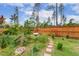 Professionally landscaped backyard featuring stone pavers, lush trees, and manicured grounds at 182 Brendamoore Ct, Fuquay Varina, NC 27526
