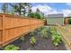 A wonderful backyard garden with raised beds, healthy crops, and a wooden fence at 182 Brendamoore Ct, Fuquay Varina, NC 27526