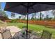 Lush backyard featuring a charming patio area with an umbrella table set, ideal for outdoor enjoyment at 182 Brendamoore Ct, Fuquay Varina, NC 27526