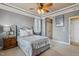A cozy bedroom featuring a tray ceiling, soft carpet, and warm ambient lighting at 182 Brendamoore Ct, Fuquay Varina, NC 27526