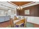 Formal dining room with an elegant chandelier, large windows, and open layout to the living room at 182 Brendamoore Ct, Fuquay Varina, NC 27526