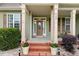 Inviting front porch featuring brick steps, potted flowers, and decorative columns at 182 Brendamoore Ct, Fuquay Varina, NC 27526