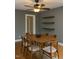 Dining room showcasing a wooden table, chairs, and floating wooden shelves on gray walls at 200 S Pettigrew St, Raleigh, NC 27610