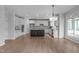 Large kitchen with stainless appliances, white cabinets, dark island, and beautiful hardwood floors at 2003 Red Sage Ct, Apex, NC 27502