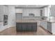 Modern kitchen featuring white cabinets, stainless steel appliances, and a contrasting dark island at 2003 Red Sage Ct, Apex, NC 27502
