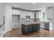 Bright kitchen features white cabinets, a dark island with light countertop, and stainless steel appliances at 2003 Red Sage Ct, Apex, NC 27502