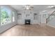 Cozy living room showcasing hardwood floors, a fireplace with built-in shelving, and large windows at 2003 Red Sage Ct, Apex, NC 27502
