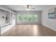 Living room with large windows providing natural light, built in shelving and wood-look floors at 2003 Red Sage Ct, Apex, NC 27502