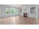 Bright living room featuring hardwood floors, a fireplace, built-ins, and large windows at 2003 Red Sage Ct, Apex, NC 27502