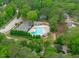 Aerial view of a community pool with ample seating, landscaping, and a parking area, surrounded by mature trees at 2003 Red Sage Ct, Apex, NC 27502