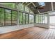 Bright sun room with wood floors, ceiling fan and multiple black framed windows at 2003 Red Sage Ct, Apex, NC 27502