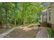 Beautiful backyard with a lush, wooded area, featuring a patio, grill, and garden path at 203 N Becket St, Cary, NC 27513