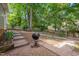 Landscaped backyard with stone steps and a grill, ideal for outdoor cooking and entertaining at 203 N Becket St, Cary, NC 27513