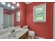 Bathroom with bright red walls, a classic sink, and a window providing natural light at 203 N Becket St, Cary, NC 27513