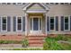 Inviting front porch with brick steps, surrounded by lush greenery and charming flower beds at 203 N Becket St, Cary, NC 27513