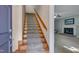 View of wooden staircase with carpet runner, leading from foyer to upper level at 203 N Becket St, Cary, NC 27513