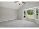 Primary bedroom with neutral walls, plush carpet, vaulted ceiling, and large window at 2213 Stephanie Ln, Clayton, NC 27520