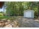 Backyard shed featuring light-blue siding and white trim, set in a wooded lot at 2213 Stephanie Ln, Clayton, NC 27520