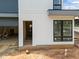 Modern home exterior featuring white siding, black windows, and an open doorway at 2321 Turners Aly, Raleigh, NC 27607
