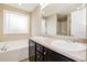 Bathroom featuring a double sink vanity, soaking tub, and a large window for natural light at 234 Lars Ln, Garner, NC 27529
