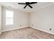 Bedroom features neutral carpet, ceiling fan, and a window for natural light at 234 Lars Ln, Garner, NC 27529