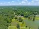 Aerial view of a community near a pond surrounded by lush greenery and mature trees at 2404 Azalea Dr, Durham, NC 27703