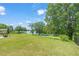 Expansive backyard featuring lush green grass and mature trees with lake views at 2404 Azalea Dr, Durham, NC 27703