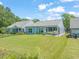 Well-maintained backyard featuring lush green grass, mature trees, and a screened-in porch at 2404 Azalea Dr, Durham, NC 27703