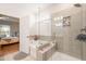 Elegant bathroom with shower, soaking tub, tile surround, and view to bedroom at 2404 Azalea Dr, Durham, NC 27703