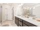 Bathroom featuring dual sinks with dark cabinets, white countertops and large mirror at 2404 Azalea Dr, Durham, NC 27703