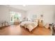 Bright bedroom with wood floors features a crib, chair and large window with sheer curtains at 2404 Azalea Dr, Durham, NC 27703