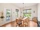 Well-lit dining room featuring hardwood floors, modern table, and outdoor views through large windows at 2404 Azalea Dr, Durham, NC 27703