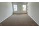 Neutral bedroom features carpeting and two bright windows at 2411 Whitewing Ln, Wendell, NC 27591